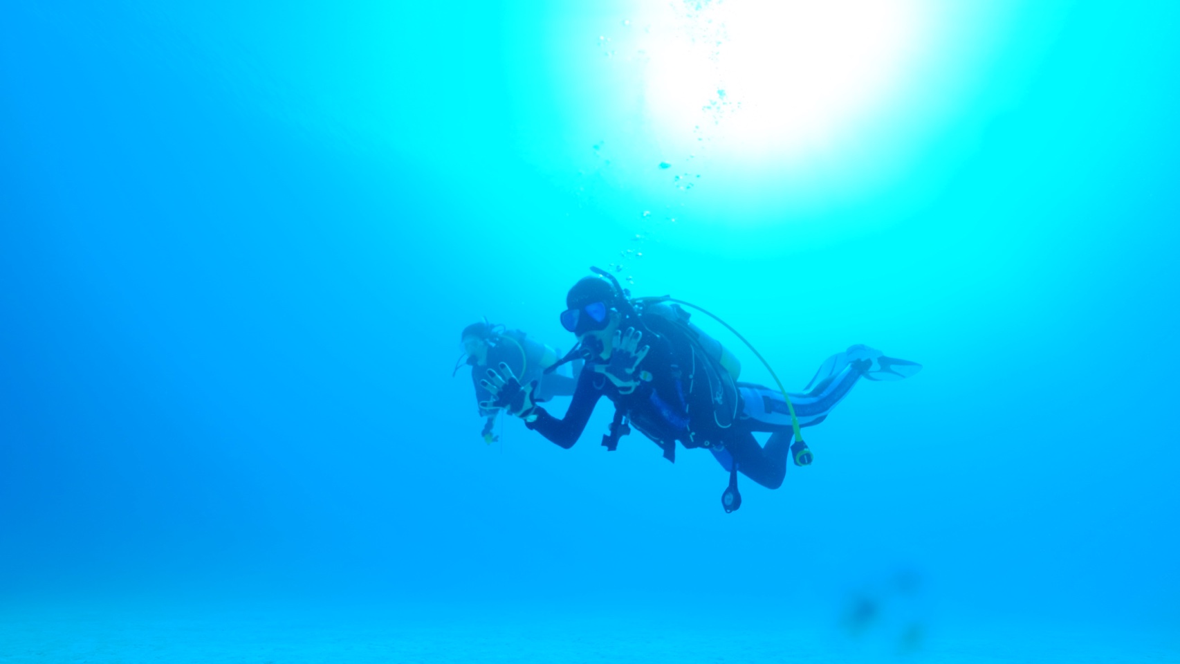 正しい潜行手順で潜るダイバーの写真